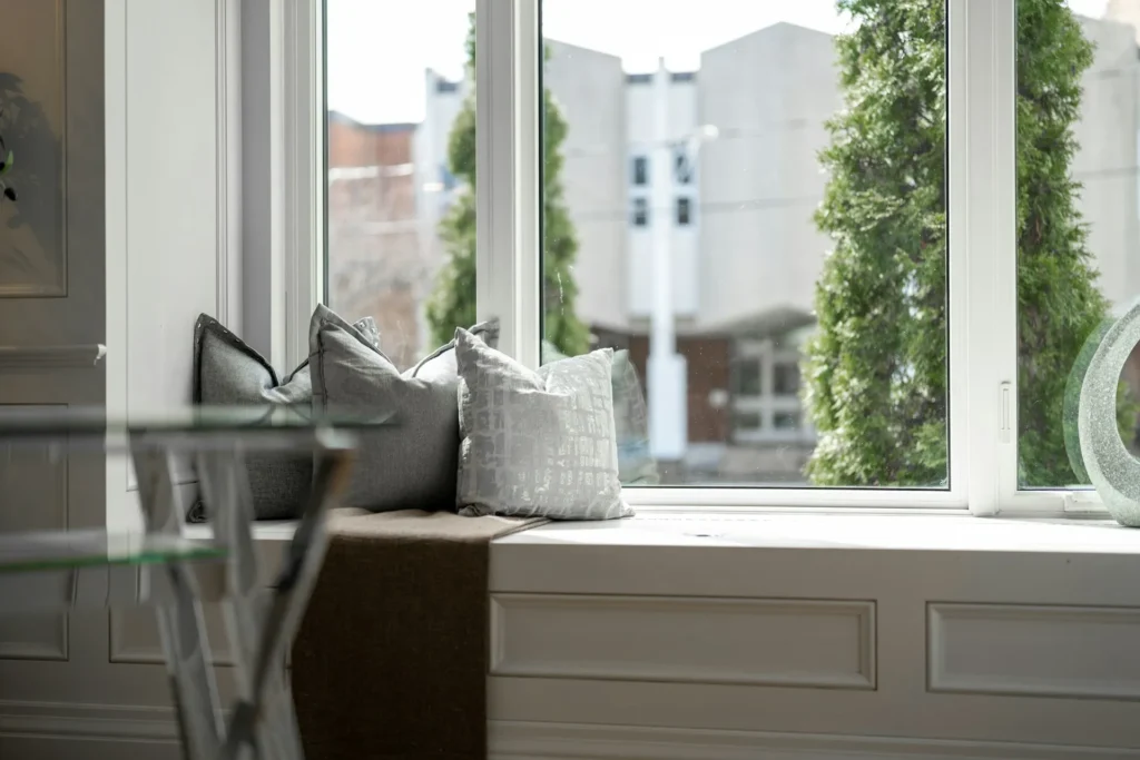 Bright modern interior with tall windows overlooking greenery.